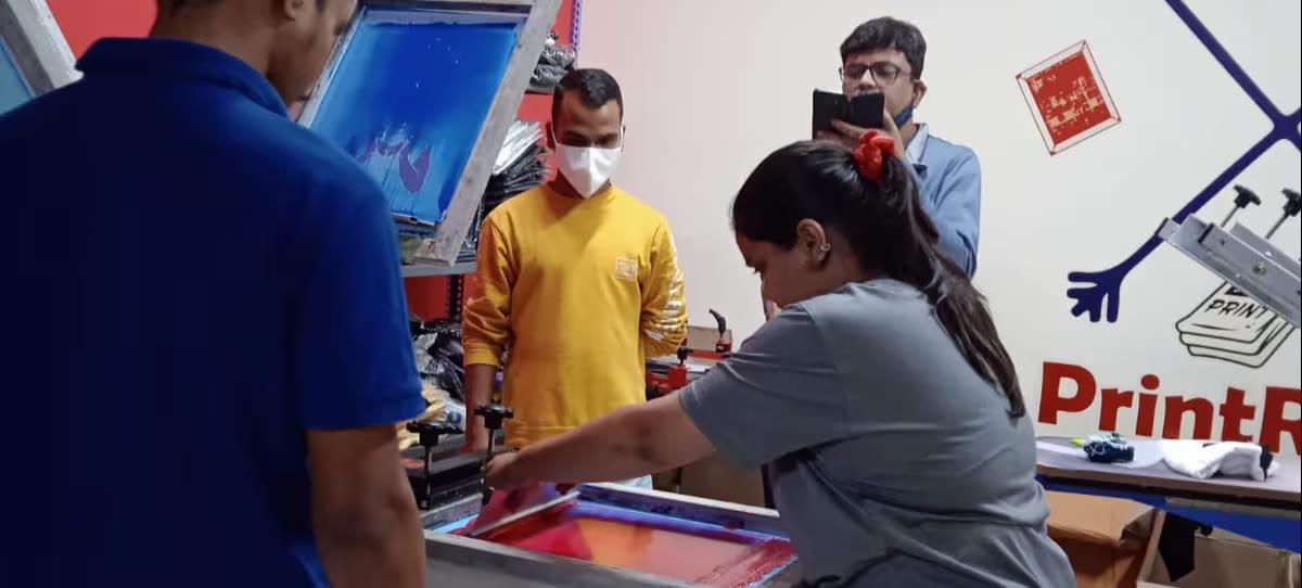 A student pulling a squeegee across a screen during hands-on practice
